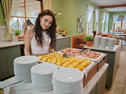 a woman standing in a kitchen preparing food at Pohorje Village Wellbeing Resort - Family Apartments Bolfenk in Pohorje