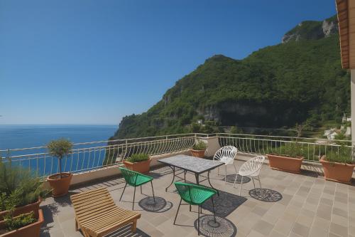 a patio with a table and chairs and the ocean at Hostel Brikette in Positano