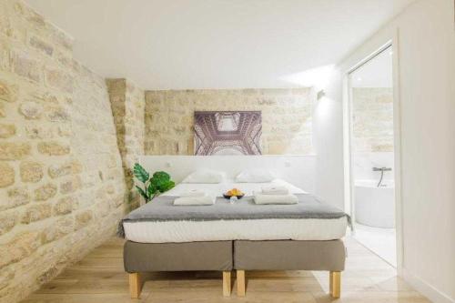 - une chambre blanche avec un lit dans l'établissement Exceptionnel duplex à proximité de Montmartre!, à Paris