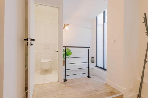 - une salle de bains avec toilettes dans une chambre blanche dans l'établissement Exceptionnel duplex à proximité de Montmartre!, à Paris