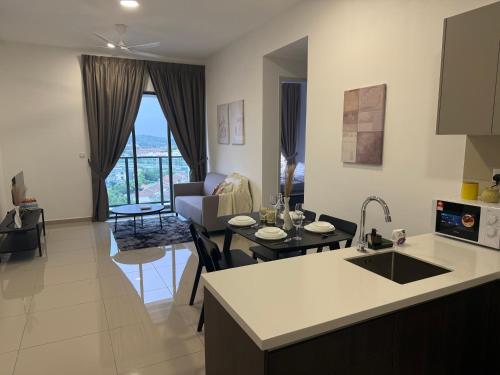 a kitchen and living room with a table and a couch at Shelisa's Modern 3BR House at Suria Garden Puchong in Puchong