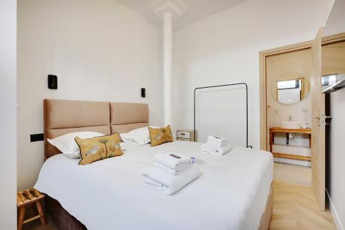 une chambre avec un lit blanc avec des serviettes dessus dans l'établissement Superbe appartement - 2BR-6P - Bastille, à Paris