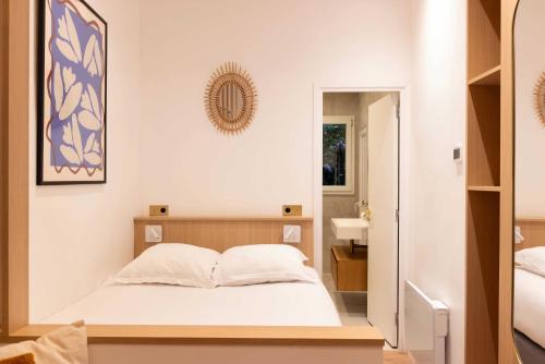 une petite chambre avec un lit et un miroir dans l'établissement Amazing studio - 2P - Arc de Triomphe, à Paris