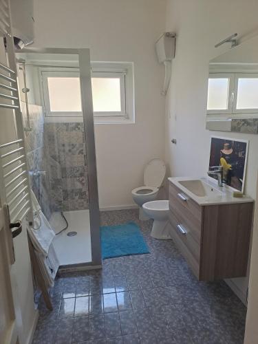 a bathroom with a shower and a toilet and a sink at Serenissima Retro Apartment in Muggia