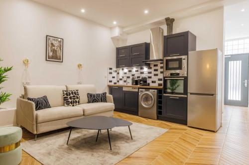 un salon avec un canapé et une cuisine dans l'établissement Charmant Appartement 2BR-6P - Gare de l'Est, à Paris