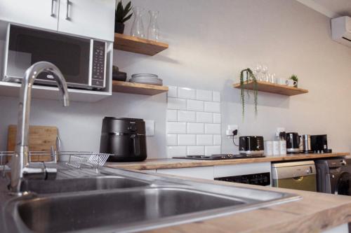 a kitchen with a sink and a microwave at Sage And Vine Studio in Worcester