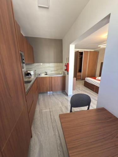 a room with a kitchen with a table and a bed at The Urban Suites in Il-Gżira
