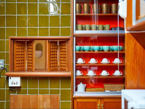 a cabinet filled with dishes and utensils at Villa花観月ー敷地7,885平方メートルー縁側で庭園を眺める贅沢 in Kasama