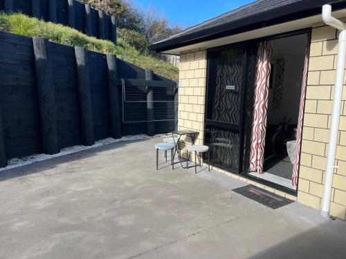 a patio with two chairs and a door with an american flag at Cute Stylish 2 bed Rooms in Rotorua