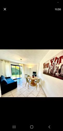 un salon avec un canapé bleu et une table dans l'établissement Appartement avec terrasse et jardin, à Royan