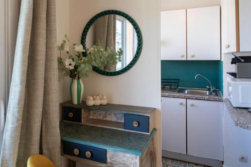 une cuisine avec un vase de fleurs et un miroir dans l'établissement #46 Terrace AC 4mins walk Sea Tram T2 Airport Port, à Nice