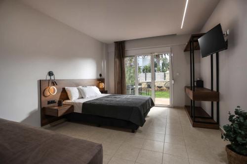 a bedroom with a bed and a tv and a window at Danae Comfort Living in Pefkochori