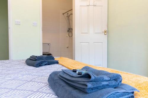 a bed with blue towels sitting on top of it at Thornbury Guest House Room 2 in Southampton