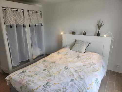 une chambre avec un lit avec une couette fleurie dans l'établissement Appartement proche disney, à Montévrain