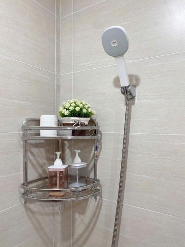 a shower head in a bathroom with a shelf at JULY Homestay Nera huế in Thôn Văn Dương