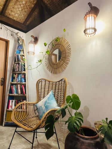 a rattan chair in a room with a mirror and a plant at Thundi Sea View in Fulidhoo