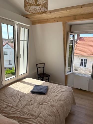 une chambre avec un grand lit et deux fenêtres dans l'établissement Magnifique maison au bord de la mer, à Le Touquet-Paris-Plage