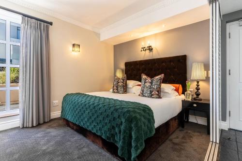 a bedroom with a large bed and a window at Romney Park Luxury Apartments by The Stay Collection in Cape Town