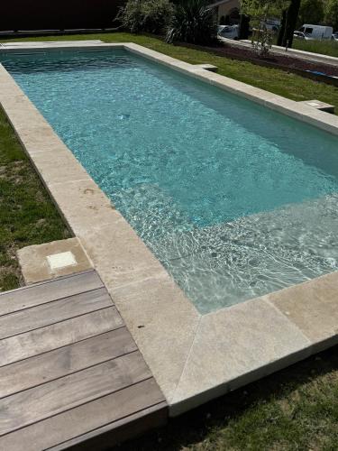a swimming pool with a wooden walkway around it at Ferme La Clavière, Suite de Luxe Lou Estello in Mane