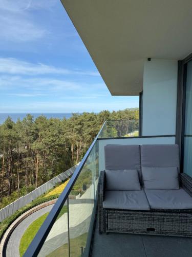a balcony with a couch and a view of the ocean at Waveview Premium Apartment Międzyzdroje in Międzyzdroje