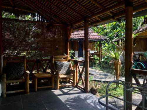 a patio with two chairs under a pergola at AlBambu in Gili Air