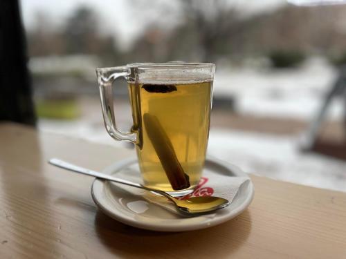 a cup of tea on a plate with a spoon at Ludwig Hotel in Martonvásár