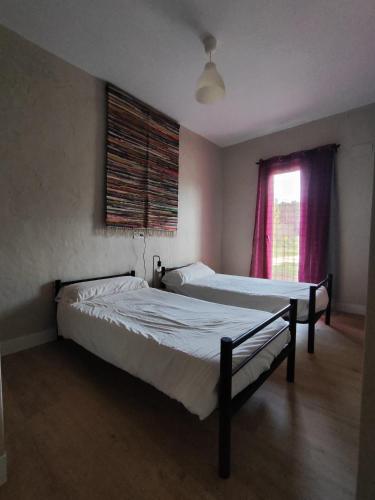two beds in a room with a window at Centro Ecoturismo Barbatona Sigüenza in Barbatona