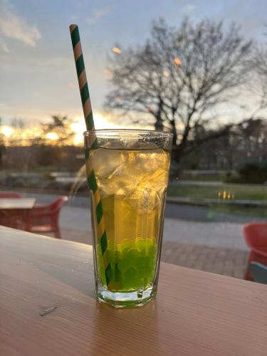 a drink with a striped straw sitting on a table at Ludwig Hotel in Martonvásár