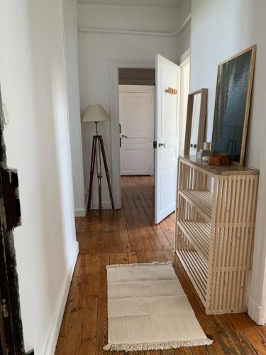 - un couloir avec une chambre dotée de murs blancs et de parquet dans l'établissement Appartement spacieux et lumineux Place Delille, à Clermont-Ferrand