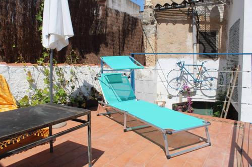 a blue chair and a table on a patio at CAL CUP Habitaciones in Bisbal del Penedès