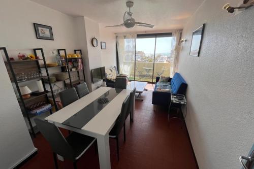 un salon avec une table et des chaises et une fenêtre dans l'établissement Comfortable apartment of 60 m in Narbonne, à Narbonne