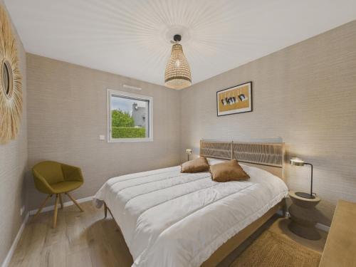 a bedroom with a large bed and a yellow chair at Maison neuve avec terrasse et jardin pour 6 in Beg-Meil