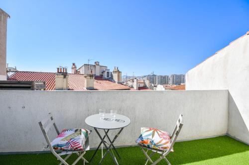 une table et des chaises sur un balcon avec vue dans l'établissement Chez Marcel - Appart 2 ch avec clim - St Charles, à Marseille