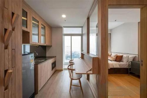 a kitchen with a desk and a kitchen with a bed at 素坤逸沿线BTS Ekkama Station in Bangkok