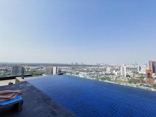 a pool on top of a building with a city at 素坤逸沿线BTS Ekkama Station in Bangkok