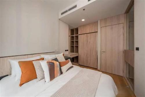 a bedroom with a large white bed and wooden cabinets at 素坤逸沿线BTS Ekkama Station in Bangkok