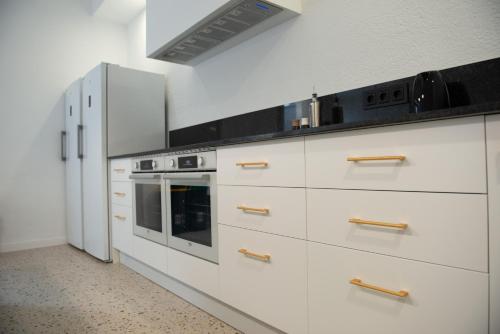 a kitchen with white cabinets and a stove at Casa Rural Mas Homs in Parets de Dalt
