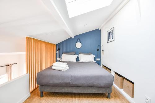 une chambre avec un lit avec un mur bleu dans l'établissement Chez Naïs - Appart 1 ch avec clim - St Charles, à Marseille