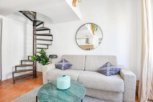 - un salon avec un canapé et un miroir rond dans l'établissement Chez Naïs - Appart 1 ch avec clim - St Charles, à Marseille