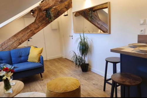 un salon avec un canapé bleu et une table dans l'établissement Grimaldi - Sous les toits de Nice, à Nice