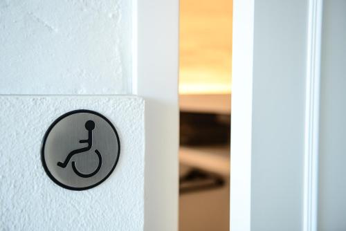 a sign on a white wall with a toilet symbol at Casa Rural Mas Homs in Parets de Dalt