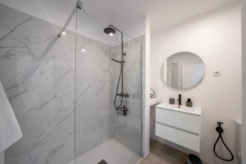 a white bathroom with a shower and a sink at Lido II by An Island Apart in Funchal