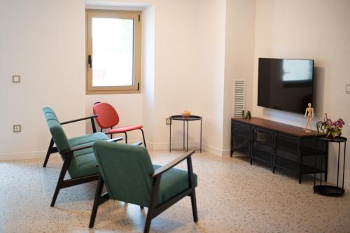 a living room with two chairs and a television at Casa Rural Mas Homs in Parets de Dalt