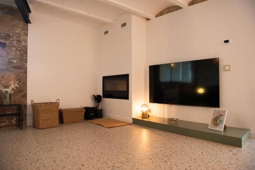 a living room with a large flat screen tv on the wall at Casa Rural Mas Homs in Parets de Dalt