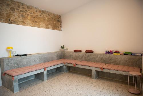 a long bench sitting in a room with a wall at Casa Rural Mas Homs in Parets de Dalt