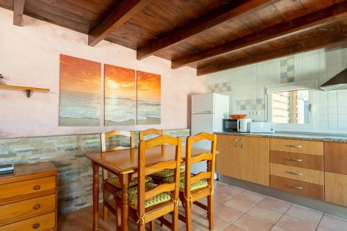 a kitchen with a wooden table and chairs at Casa 2 Hermanas Formentera in Illes Balears