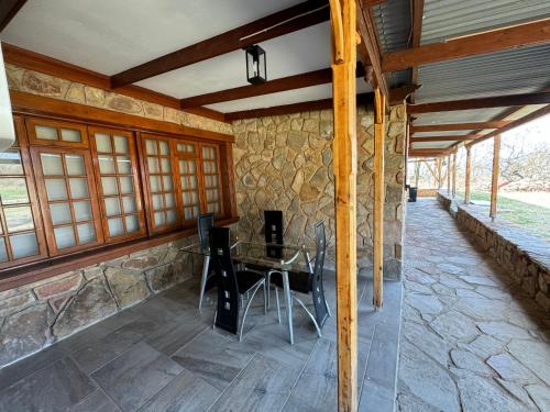 a dining room with a table and a stone wall at Nectar Game Lodge in Buffelspoort