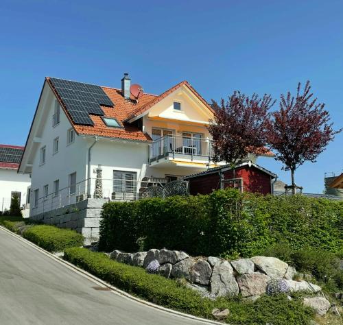 a white house with solar panels on the roof at Guesthouse Ritzmann in Grafenhausen