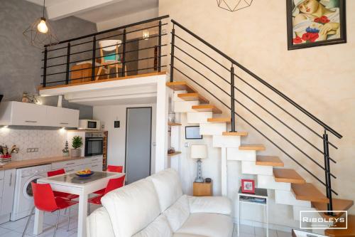 - un salon avec un canapé blanc et un escalier dans l'établissement Charmante maison climatisée à 500m de la plage, à Vias