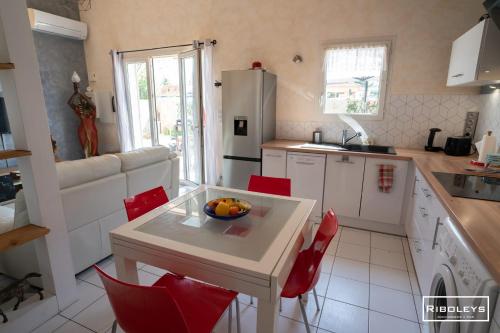 une cuisine avec une table avec un bol de fruits dessus dans l'établissement Charmante maison climatisée à 500m de la plage, à Vias